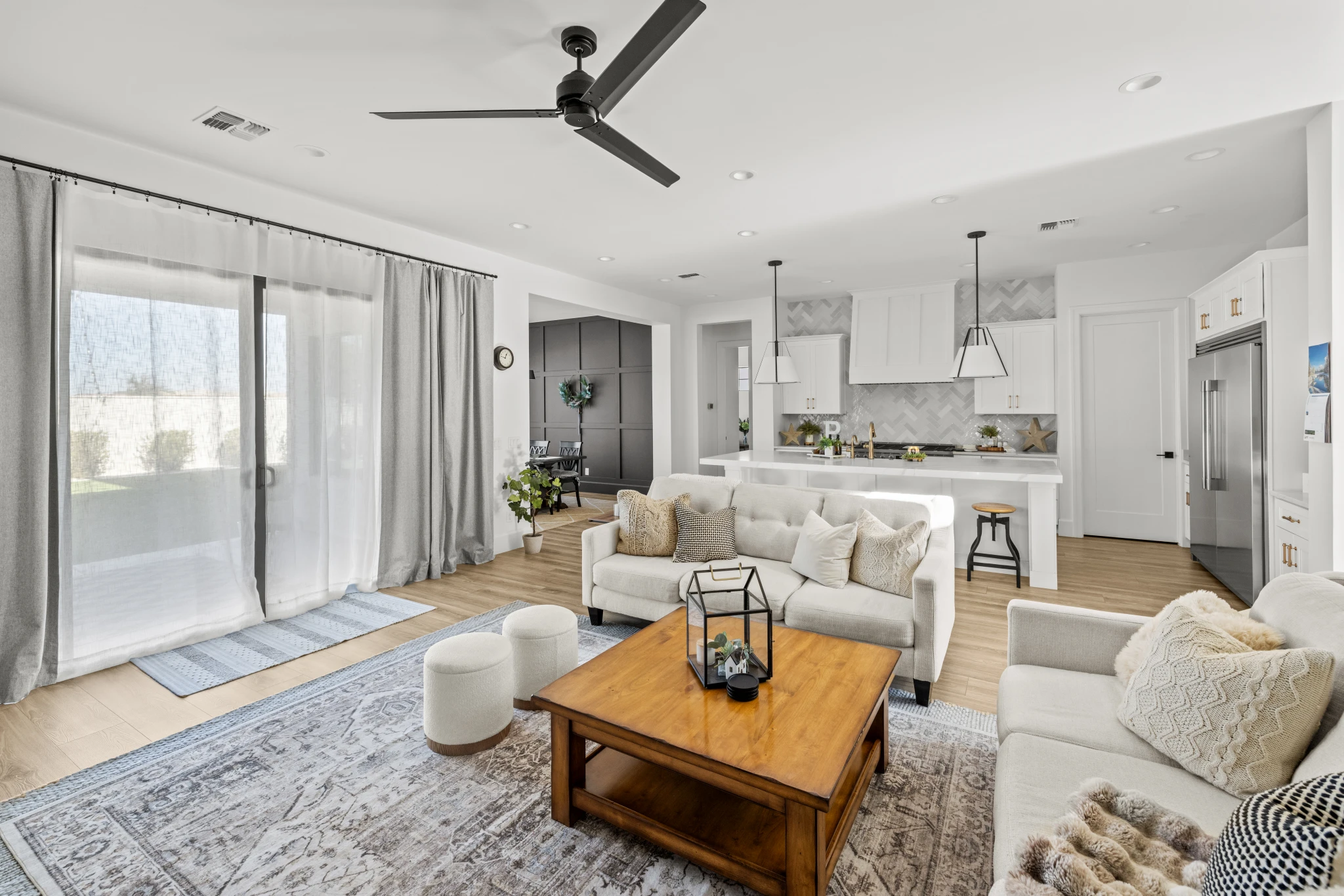 A bright and inviting open-concept living room and kitchen with modern furnishings and natural light. Photographed by Shane Baker Studios.