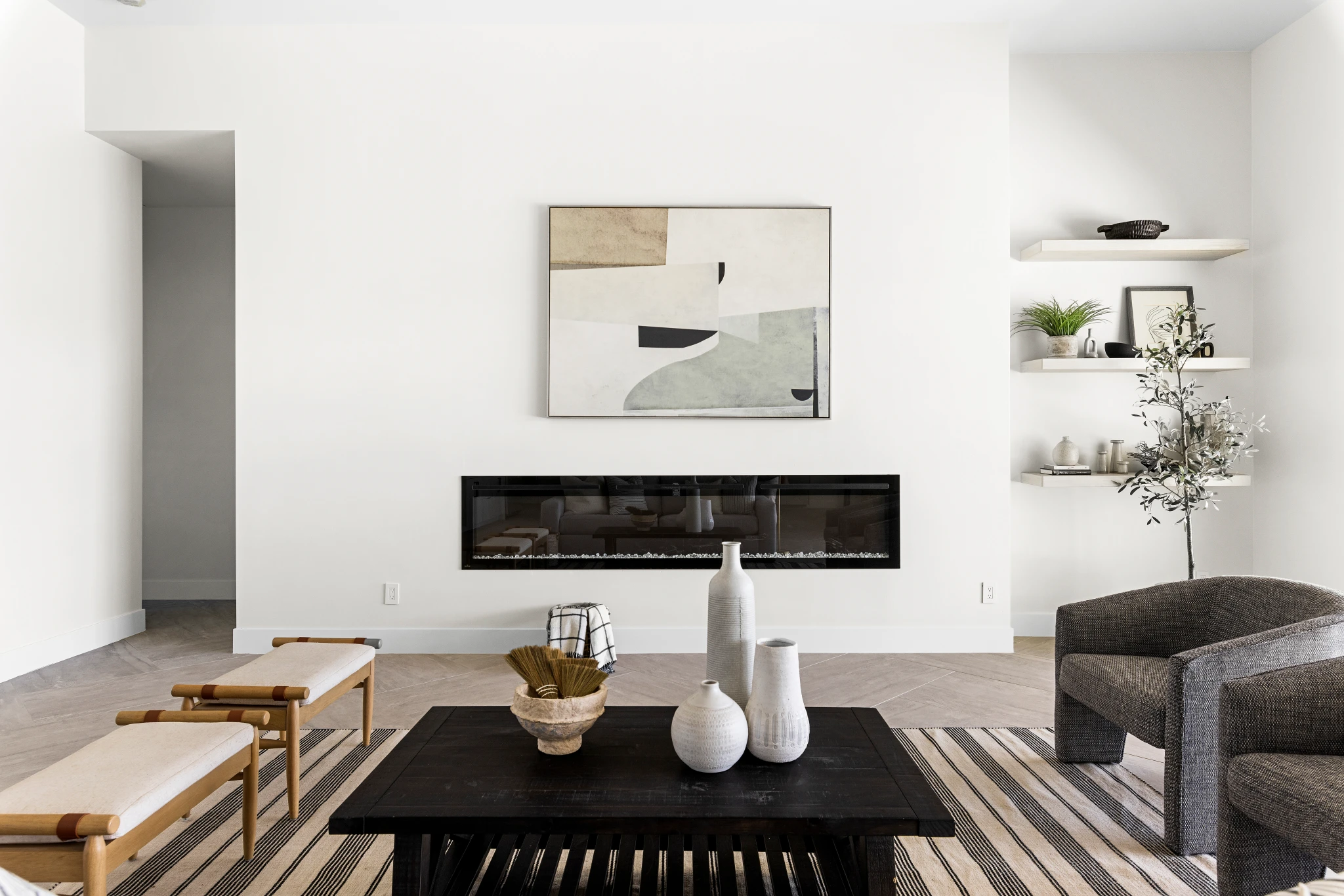 A modern living room with a sleek linear fireplace, minimalist decor, and neutral tones. Photographed by Shane Baker Studios.